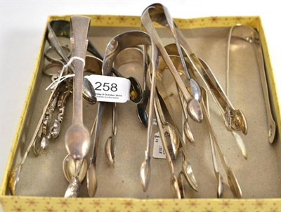 Lot 258 - Thirteen pairs of George III and later silver sugar tongs and two pairs of scissor action sugar...
