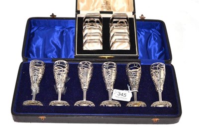 Lot 345 - A cased pair of silver toast racks, Sheffield hallmark and a cased set of six silver overlaid...