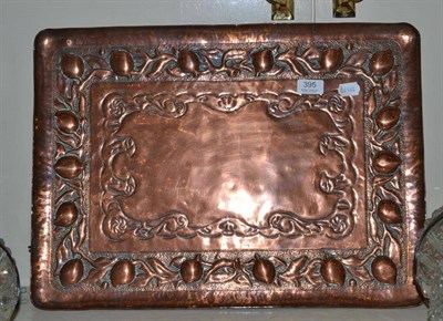 Lot 395 - A large Arts & Crafts Newlyn copper embossed tray, the border with a fruit pattern, design...