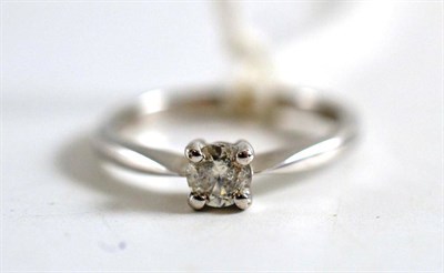 Lot 410 - A diamond solitaire ring, the round brilliant cut diamond in a white four claw setting, to a...