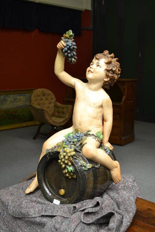 Lot 91 - A Continental Pottery Large Figure of a Naked Boy Astride a Wine Barrel, probably German, circa...