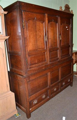 Lot 670 - An 18th century joined oak livery cupboard, with fielded panel doors enclosing later shelves,...