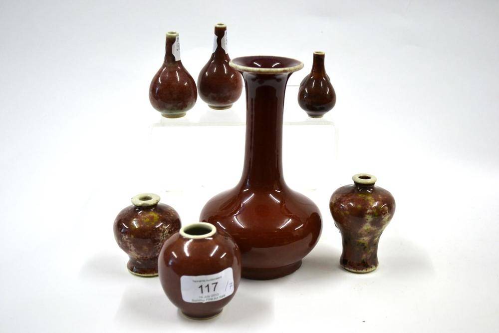 Lot 117 - A Chinese Sang de Boeuf Glazed Porcelain Bottle Vase, 18th/19th century, with tall cylindrical neck