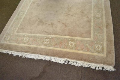 Lot 704 - Nepali rug, the plain mushroom field enclosed by floral borders and cream guard stripes, 303cm...