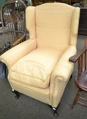 Lot 729 - A wing back chair upholstered with yellow fabric