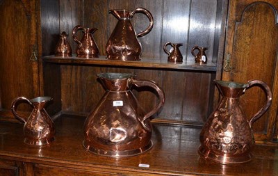 Lot 786 - A Harlequin set of eight copper measuring jugs