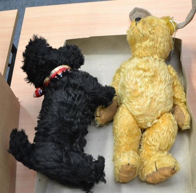 Lot 984 - Yellow plush jointed teddy bear and a black Scottie Dog with tartan ribbon (2)