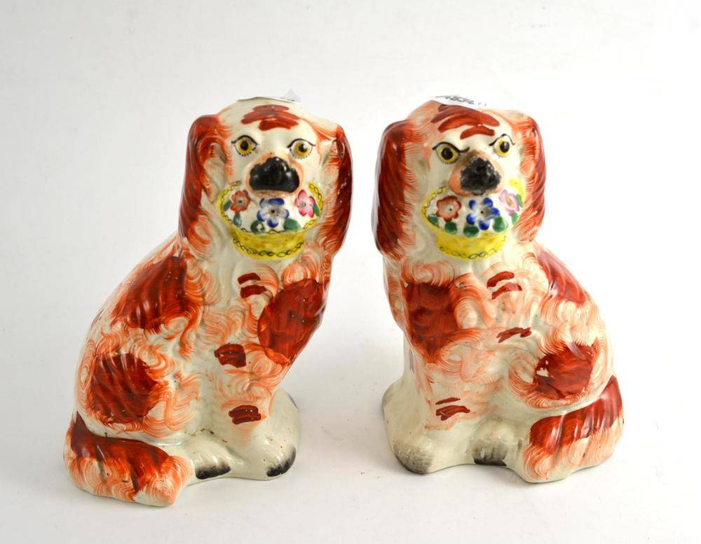Lot 246 - Pair of Staffordshire spaniels holding a basket of flowers