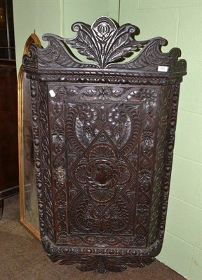 Lot 380 - A 19th century heavily carved oak wall cabinet