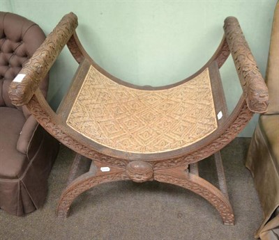 Lot 387 - An x-framed stool with caned seat