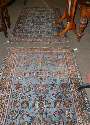 Lot 417 - A pair of light blue ground rugs within a peach border and a modern red patterned rug (3)