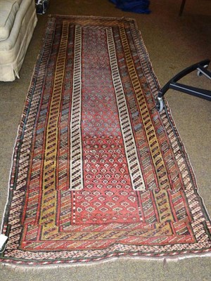Lot 456 - Narrow North West Persian runner, the narrow madder field of boteh enclosed by multiple...