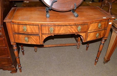 Lot 471 - An early 19th century mahogany bowfront dressing table, fitted with three frieze drawers, two...