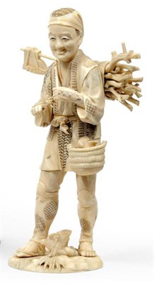 Lot 217 - A Japanese Walrus Ivory Composite Figure of a Woodman, circa 1910, carrying his axe and a bundle of