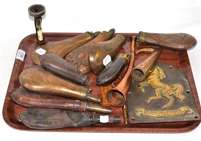 Lot 136 - Six copper powder flasks, three leather shot flasks, a plaque mounted with a brass horse over...