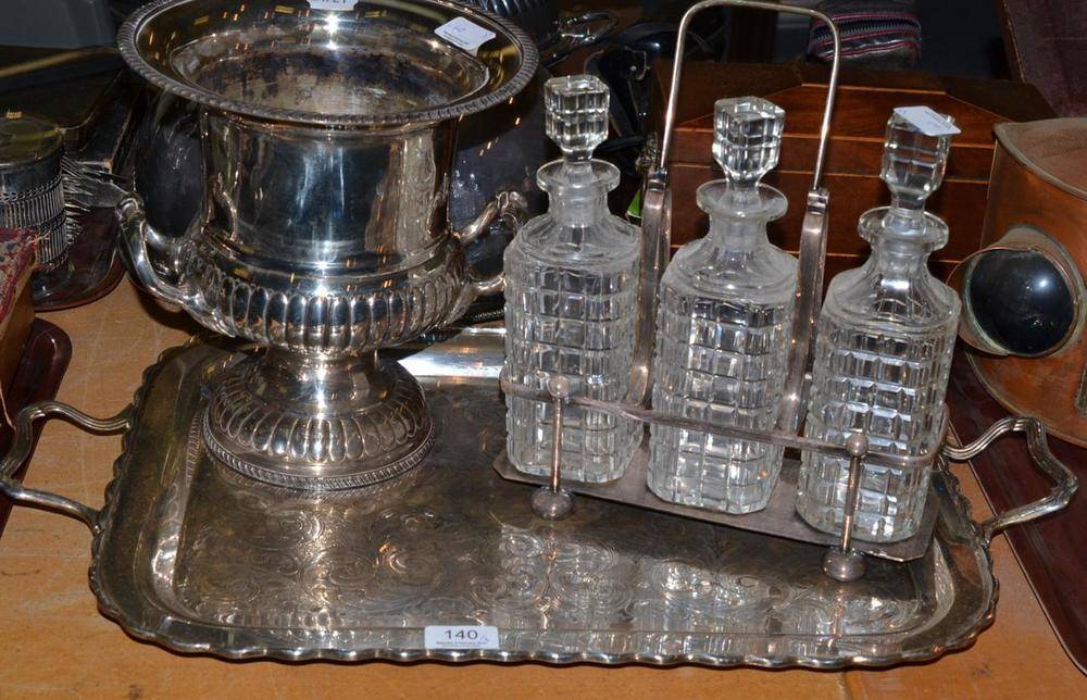 Lot 140 - A silver plated three bottle decanter stand with cut glass decanters, a wine cooler and a twin...