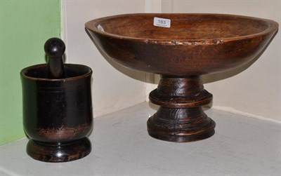 Lot 183 - A European carved wooden dairy bowl on a double stepped base, also a treen pestle and mortar