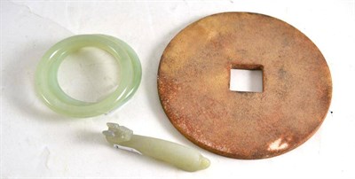 Lot 284 - A carved stone 'bi' disc, a jade type small belthook and two bracelets