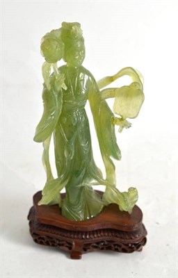 Lot 285 - A jade-type carved green stone Guanyin on wood stand