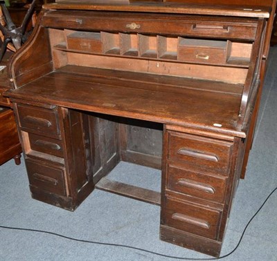 Lot 412 - An early 20th century oak twin pedestal desk with tambour top and fitted interior