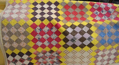 Lot 442 - A yellow ground quilt with geometric square patchwork patterns, with a plain cream reverse,...