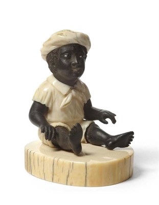 Lot 250 - A Continental Carved Elephant Ivory and Ebony Figure of a Seated Nubian Boy, 19th century,...