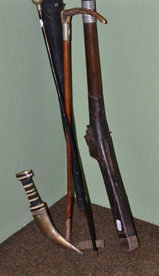 Lot 129 - An Indian matchlock long gun, a Moroccan Khanjar, a malacca hunting whip, a swagger stick and...