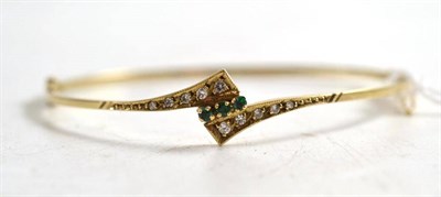 Lot 150 - A 9ct gold emerald and diamond bangle