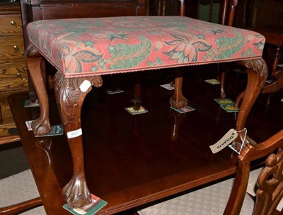 Lot 451 - An upholstered dressing stool with shell capped cabriole legs and ball and claw feet