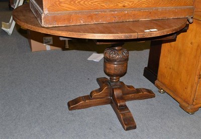 Lot 599 - An oak draw leaf dining table on a single pedestal