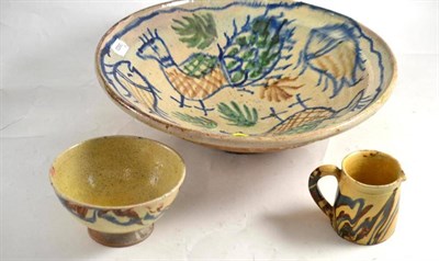 Lot 63 - A slipware pottery peacock bowl, a slipware milk jug and bowl (3)