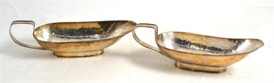 Lot 86 - A pair of Arts and Crafts planished white metal sauceboats, stamped 'Silver' and 'PW'