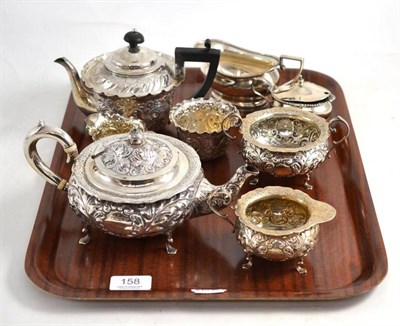 Lot 158 - A composite silver tea service by Walker & Hall, each piece heavily chased with flowers and foliate
