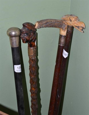 Lot 186 - A walking stick, the handle carved as the head of a sailor; a walking stick, the bone handle carved