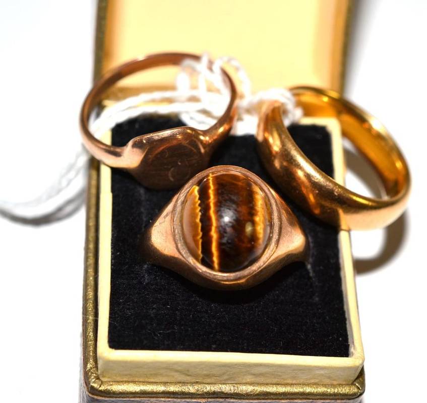 Lot 25 - A 22ct gold band ring, a 9ct gold tiger's-eye ring and a signet ring