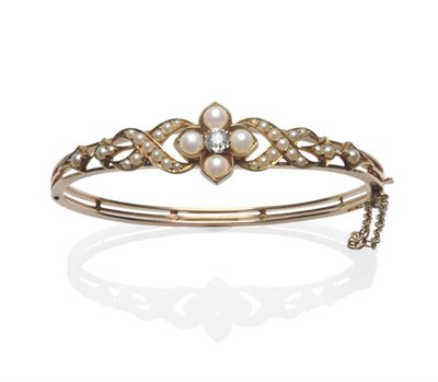 Lot 391 - A 9 Carat Gold Diamond and Seed Pearl Bangle, the old cut diamond in a yellow claw setting...