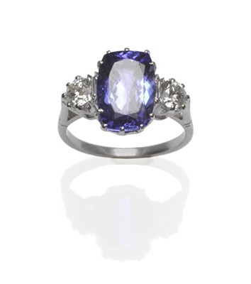 Lot 407 - A Tanzanite and Diamond Three Stone Ring, the cushion cut tanzanite flanked by a round...