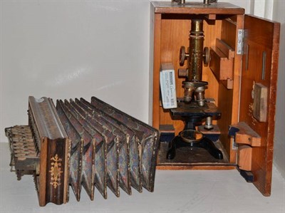 Lot 262 - A Leitz student microscope, cased and an inlaid rosewood accordion with mother-of-pearl keys