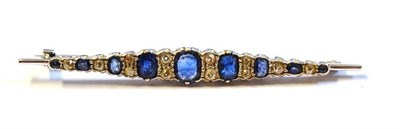 Lot 416 - A Diamond and Sapphire Bar Brooch, the cushion shaped sapphires alternate with old cut diamonds, in