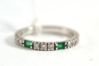 Lot 362 - An emerald and diamond half eternity ring