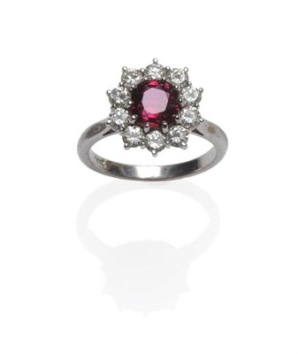 Lot 420 - A Ruby and Diamond Cluster Ring, a cushion shaped ruby within a border of ten round brilliant...