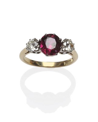 Lot 421 - A Ruby and Diamond Three Stone Ring, the round mixed cut ruby flanked by a round brilliant cut...