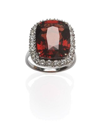 Lot 424 - An 18 Carat White Gold Garnet and Diamond Cluster Ring, the cushion cut garnet within a border...