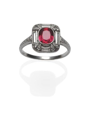 Lot 428 - A Ruby and Diamond Ring, the oval mixed cut ruby in a white bezel setting, in a pierced border...