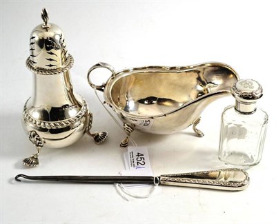 Lot 452 - A silver caster, sauceboat, button hook and scent bottle