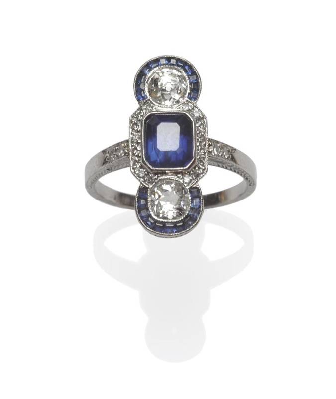 Lot 439 - A Sapphire and Diamond Ring, a central step cut sapphire within a part border of eight-cut...