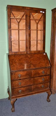 Lot 614 - A walnut bureau with later glazed top