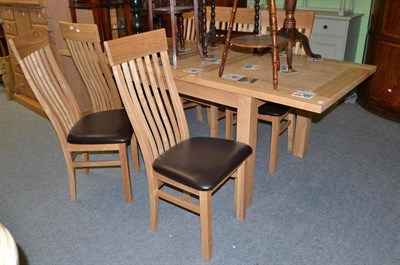 Lot 621 - A modern light oak extending dining table with six matching chairs