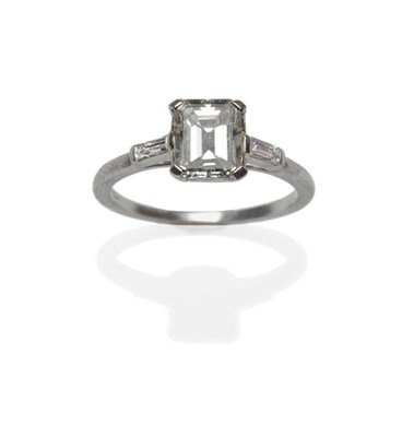 Lot 442 - A Diamond Solitaire Ring, the emerald-cut diamond in a white corner claw setting, to shoulders...