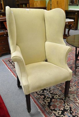 Lot 650 - Wingback armchair on brass castors